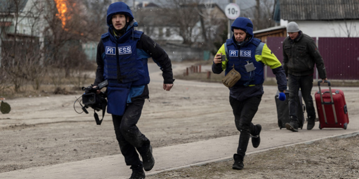 Журналісти тікають в укриття після потужних обстрілів в Ірпені поблизу Києва, 6 березня 2022 року. Фото – Reuters / Carlos Barria